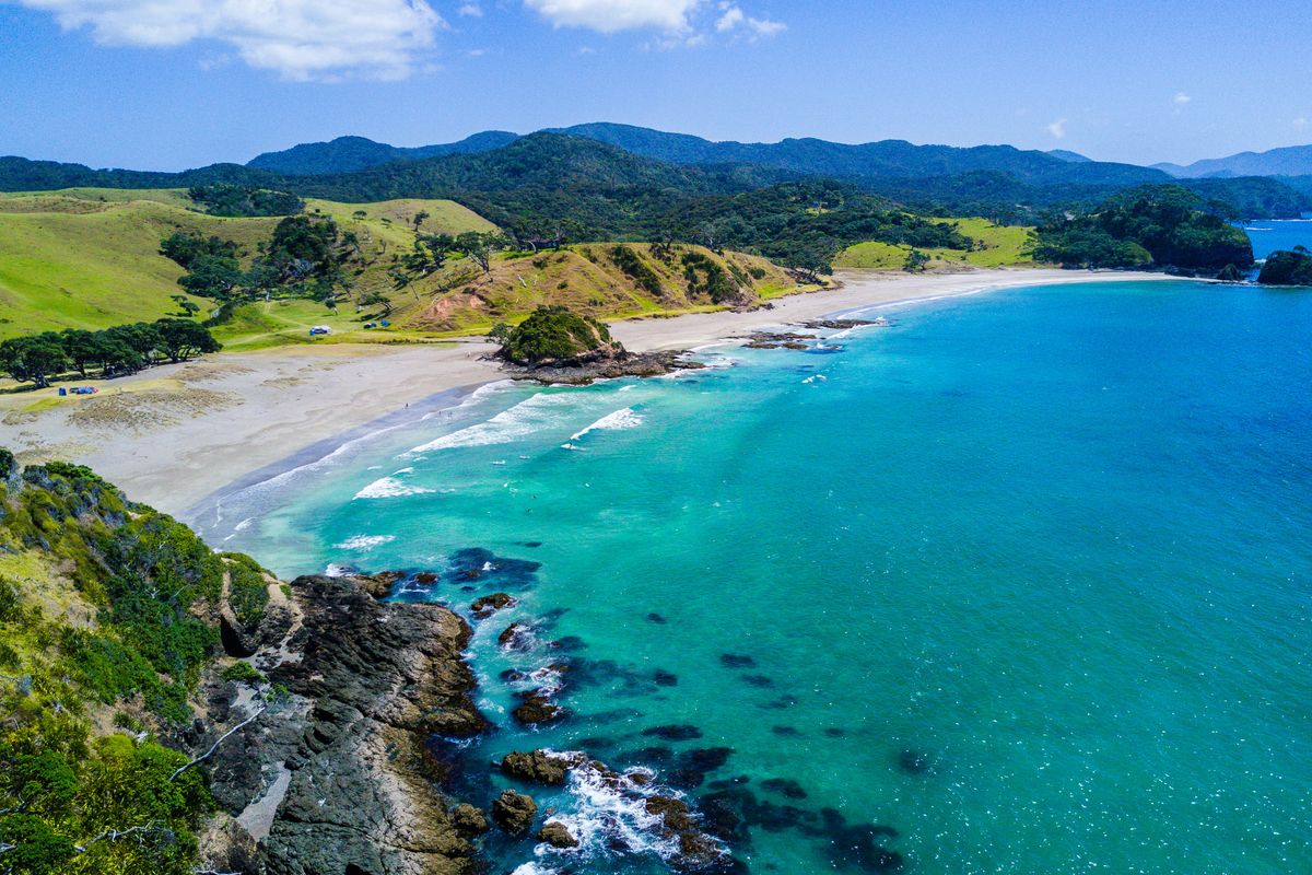 Sandy beach and green hills along the Northland coast near Whangarei