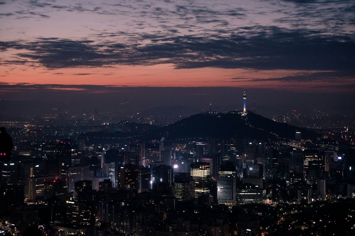N Seoul Tower lit up on Namsan Hill at dusk